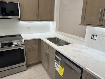 The sleek, polished surface of the quartz countertops reflec...